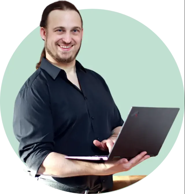 © stepbyweb Portrait von Geschäftsführer Stefan Jäger in dunklem Hemd mit Laptop